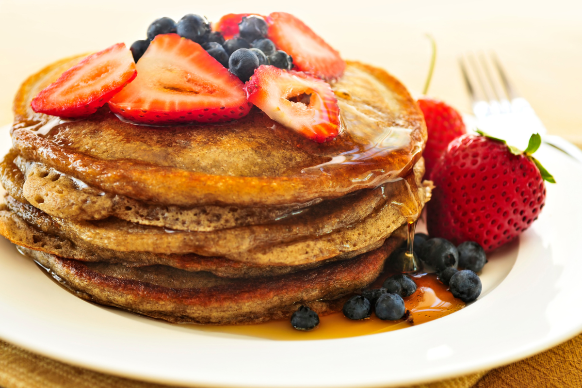 three ingredient banana mixed berry pancakes piled on a plate