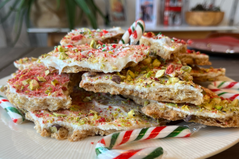 Peppermint Pistachio and white chocolate cookie bark stacked with a candy cane