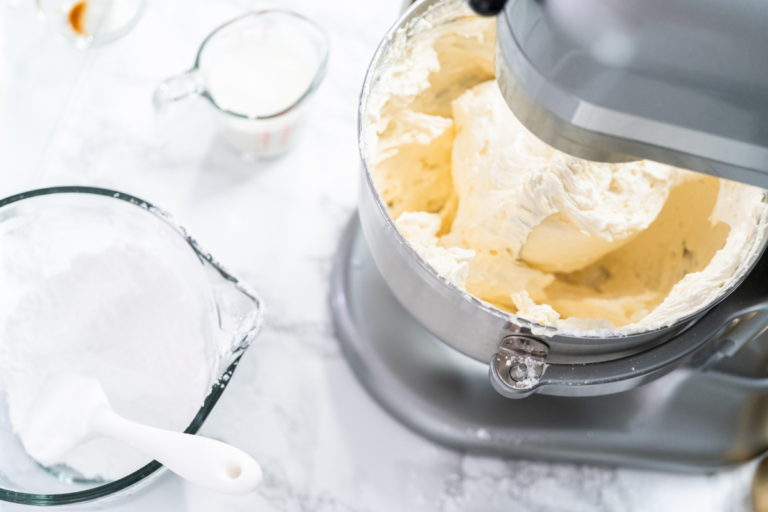 vanilla buttercream frosting being whipped in a mixer